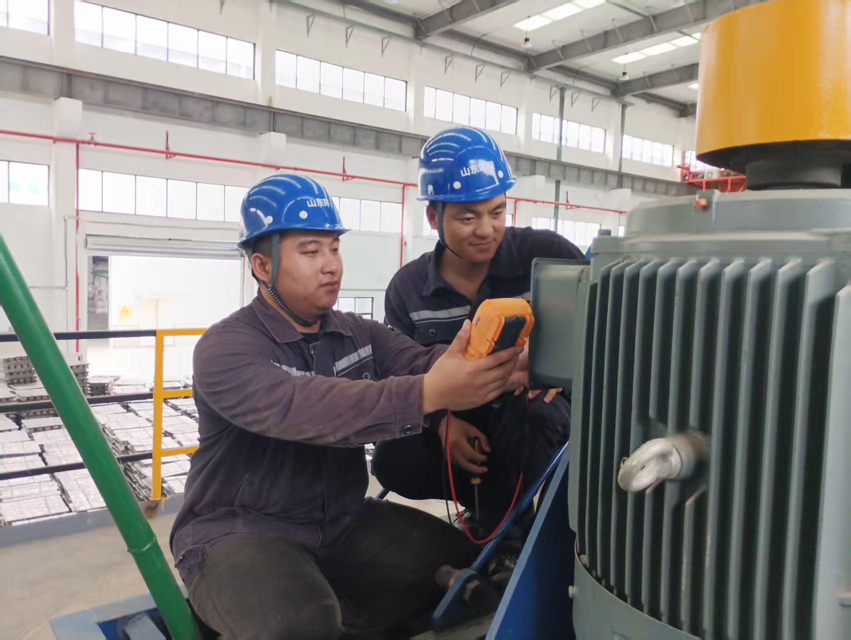 圖為景紅富（左）與同事一起檢修設(shè)備.jpg